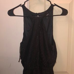 A halter black dress with sparkles and texture .